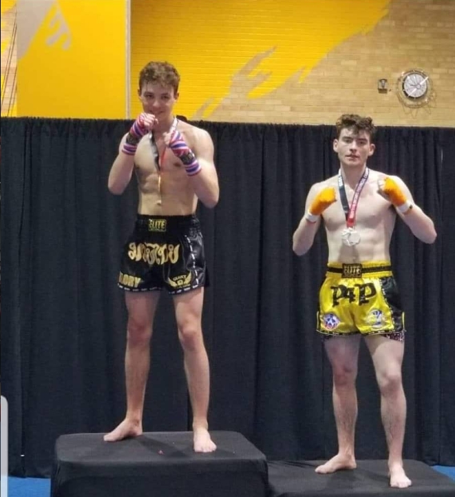 Two young Glory Muay Thai fighters with their medals